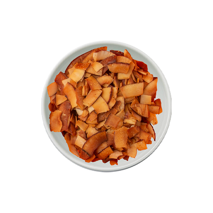 Dried caramel coconut chips in a white bowl. Distributed by AFRIVANA